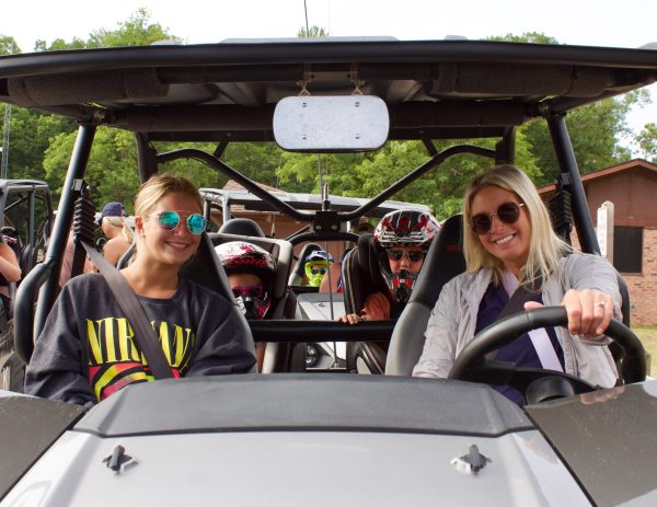a group of people sitting around a car